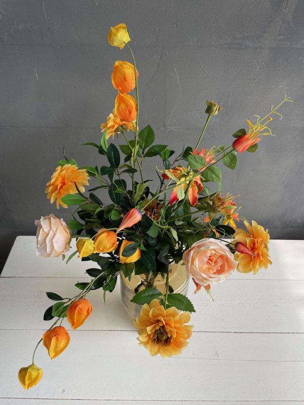 Energiek boeket met oranjerode dahlia en Chinese lampion-plant in glasvaas