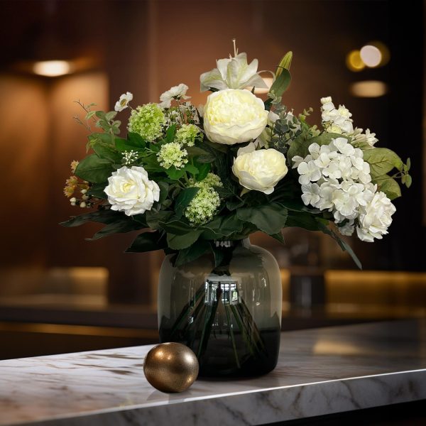 Weelderige witte pioenrozen en hortensia in donkergroene vaas