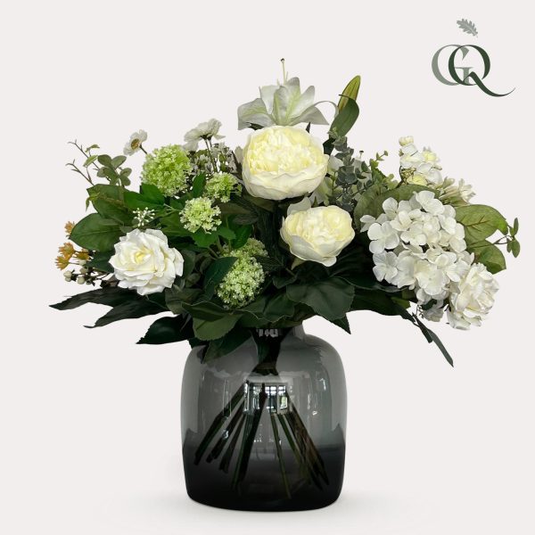 Witte pioenrozen en hortensia in een smoky glazen vaas