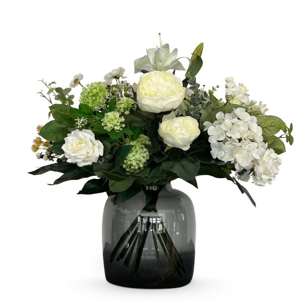 Wit boeket met pioenrozen, rozen en hortensia in strakke glazen vaas